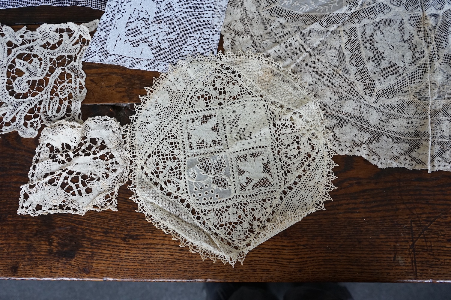A good collection filet lace including a wide figurative elephant panel, square inserts, mats, trimming etc, with two Normandy lace mats, a cutwork mat and bobbin lace inserts.(40). Fillet panel 112cm long x 27cm wide. C